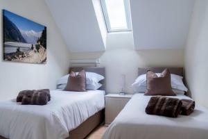two beds sitting next to each other in a bedroom at Superb 4BD Stay in Wyton and Houghton Village in Wyton
