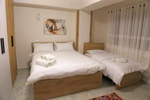 - une chambre avec 2 lits et des serviettes dans l'établissement Modern Marvel Apartment, à Krujë