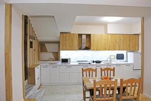 une cuisine avec une table et des chaises dans l'établissement Modern Marvel Apartment, à Krujë