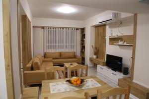 - un salon avec un canapé et une table avec des oranges dans l'établissement Modern Marvel Apartment, à Krujë