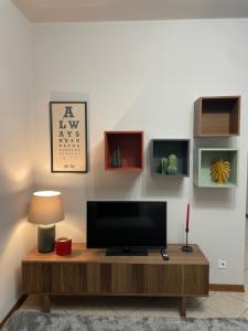 a living room with a television on a wooden table at Mille4 in Novara