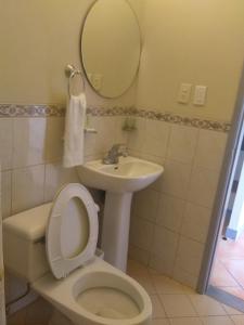 y baño con aseo, lavabo y espejo. en Hotel Caridi, en Salinas