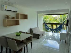un salon avec une table et des chaises et un balcon dans l'établissement Porto Beach Resort - Beach Class Muro Alto, à Porto de Galinhas