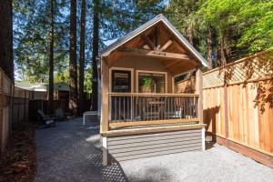 a small wooden cabin with a fence and trees at Enchanting Retreat in the heart of Redwoods in Guerneville