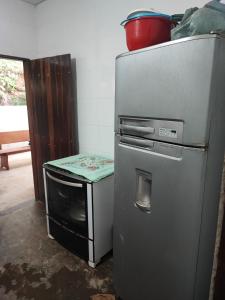 a refrigerator and a table in a kitchen at Sitio Cheiro Do Campo in Jaboticatubas