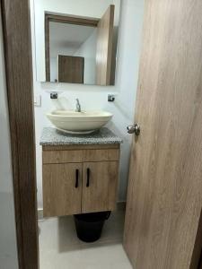 uma casa de banho com um lavatório e um espelho em Apartaestudio 203 Gaitán em Bogotá