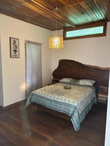 a bedroom with a bed and a chandelier at Casita Flor de Loto in Puerto Viejo