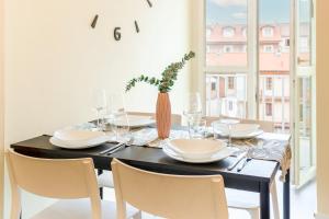 都靈的住宿－Vista Mole, Centro a 15 min - Luxury Suites & fast WiFi，餐桌,配有白色的盘子和椅子