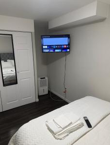 a bedroom with a bed with a flat screen tv on the wall at Comfortable 3 Bed Basement Unit in Winnipeg