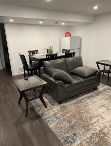uma sala de estar com um sofá e uma mesa em Comfortable 3 Bed Basement Unit em Winnipeg
