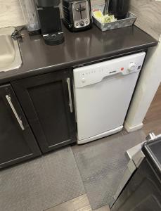 a kitchen with a white dishwasher next to a counter at Comfortable 3 Bed Basement Unit in Winnipeg