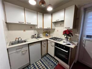 a kitchen with white cabinets and a sink and a stove at Central Location shops & beach in Milford on Sea