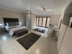 a large bedroom with a bed and a table at Grants Hill Inn in Bloemfontein