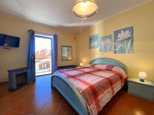 1 dormitorio con 1 cama, TV y ventana en Sunrise Inn & Spa en Pessinetto