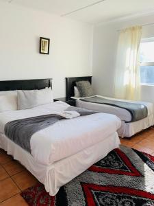 a bedroom with two beds and a window at Beach View B&B in East London