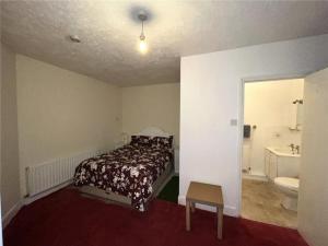 a bedroom with a bed and a bathroom with a sink at Central Location shops & beach in Milford on Sea