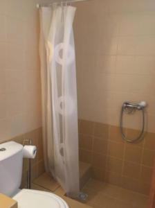 einen weißen Duschvorhang im Bad mit WC in der Unterkunft Soltroia Beach House in Carvalhal