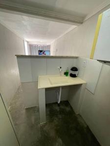 a bathroom with a sink and a person in a window at Quitinete da Nicole in Canindé de São Francisco