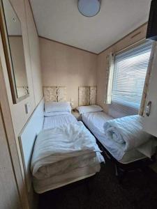 a room with two beds and a window at Jayden in Rhyl