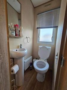 La petite salle de bains est pourvue de toilettes et d'un lavabo. dans l'établissement Jayden, à Rhyl