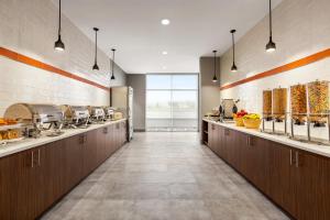 a large kitchen with brown cabinets and a counter top at Hawthorn Extended Stay by Wyndham Mount Laurel Moorestown in Mount Laurel