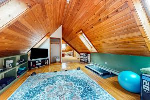an attic room with a wooden ceiling and a large rug at Hawk 1 in Pittsfield