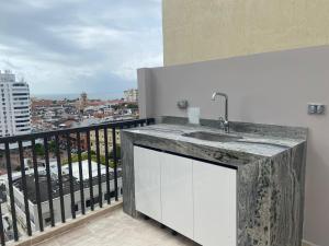 uma cozinha com um lavatório e uma varanda em Moderno dúplex tipo loft 1BR em Cartagena das Índias