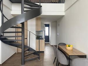 escalera de caracol negra en una sala de estar con mesa en Moderno dúplex tipo loft 1BR, en Cartagena de Indias