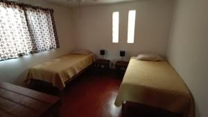 Un dormitorio con dos camas y dos ventanas. en Punta Pequena, en San Juanico 5 fotos más