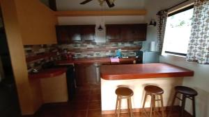 Una cocina con una barra con taburetes. en Punta Pequena, en San Juanico