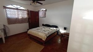 Un dormitorio con una cama y dos ventanas. en Punta Pequena, en San Juanico