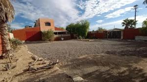 Un patio vacío con un edificio y una valla. en Punta Pequena, en San Juanico