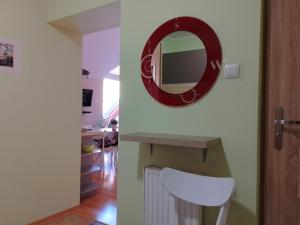 a bathroom with a mirror and a white chair at Apartament Alias in Wisła