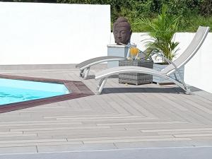 una mesa de patio y una estatua junto a una piscina en L'INSTANT PRESENT, en Le Moule