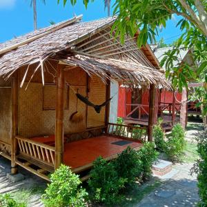 een kleine hut met een rieten dak bij New Andaman Bay Bungalow in Koh Lanta