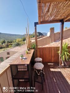 a patio with a table and stools on a roof at L'ÉTAPE BIEN ÊTRE,chambres et tables d'hôtes,épicerie Café, salon de massage in Camps-sur-lʼAgly +55 photos