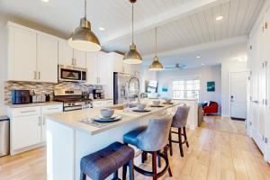 a kitchen with white cabinets and a large island with bar stools at House on the Hill in Keetley Junction