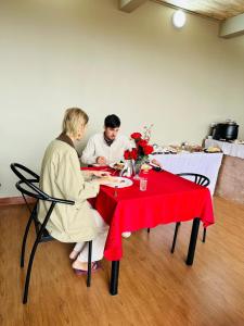 two people sitting at a table with a red table cloth at Greenside Hotel in Arusha