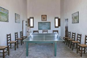 サント・ハウメ・デンヴェハにあるMas Illa de Riu - Auténtica Masía del Delta del Ebro con capacidad para 20 personas - Deltavacacionesの卓球台と椅子が備わる客室です。