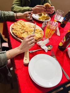 um grupo de pessoas sentadas à mesa a comer pizza em Greenside Hotel em Arusha