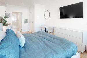 a bedroom with a large bed with a tv on the wall at Mellow on Meadow Mile 2B in Fraser