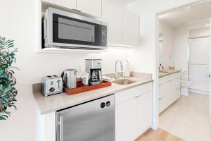 una cocina blanca con microondas sobre un fregadero en Mellow on Meadow Mile 2B en Fraser
