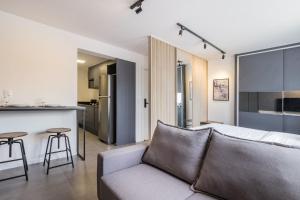 a living room with a couch and a kitchen at Duque by My Way - 100 meters from Santa Casa and UFRGS in Porto Alegre
