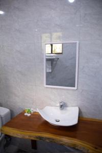 a bathroom with a white sink and a mirror at Greenside Hotel in Arusha