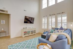 a living room with a blue couch and a tv at Shuttle to Beach Millville Townhome with Porch in Millville