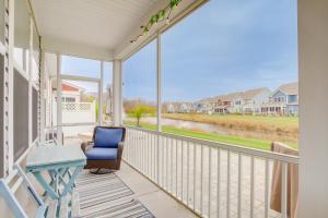 a balcony with a blue chair and a table at Shuttle to Beach Millville Townhome with Porch in Millville