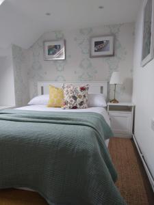 a bedroom with a bed with a green comforter at The Green Dragon in Bishops Frome