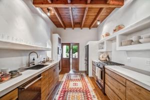 a kitchen with white walls and wooden ceilings at Hacienda Hideaway in Rancho Mirage