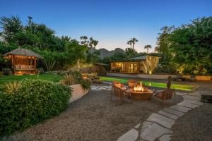 a backyard with a fire pit and a house at Hacienda Hideaway in Rancho Mirage