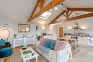 a living room with a couch and a kitchen at The Garden House in Low Catton 